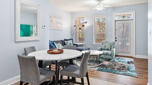 A dining area with a round table, grey upholstered chairs, and a ceiling fan. - 2 Bikes! Steps to the Pool! Bike to Beach! 1st Fl Condo! - Silk Beach on 30A at Topsail Village (Santa Rosa Beach)