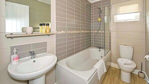 A bathroom with two sinks, a bathtub, a toilet, and a shower. - 2 bedroom accommodation in Welburn (Welburn)
