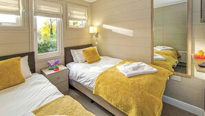 A hotel room with two beds, a large mirror, and a window with blinds. - 2 bedroom accommodation in Welburn (Welburn)