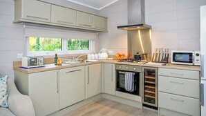A modern kitchen with a built-in oven, a microwave, and a gas stove. - 2 bedroom accommodation in Welburn (Welburn)