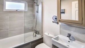 Un baño con ducha, inodoro y lavabo.