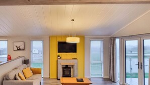 Una sala de estar con sofá, mesa de centro, chimenea y televisor.