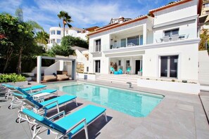 A modern pool area with lounge chairs and a clear pool.