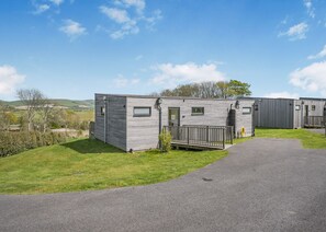 A row of mobile homes with a paved driveway and grassy areas.