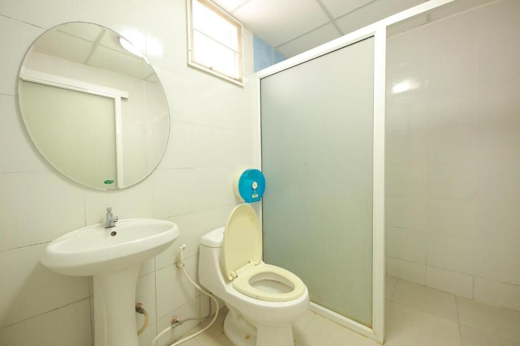 Een badkamer met een wit wastafel, toilet en spiegel.