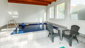 A swimming pool with a wooden ceiling, two chairs, and a ladder. - Vacation home Nimrod by Interhome (Balatonfenyves)