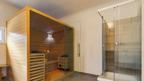 A sauna room with wooden slats, a bench, and a glass shower enclosure. - Vacation home Nimrod by Interhome (Balatonfenyves)