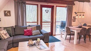 A cozy living room with a sofa, coffee table, and dining area. - Waldrauschen by Interhome (Bad Arolsen)