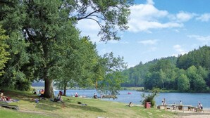 A lakeside park with picnic areas, a sandy beach, and a large tree providing shade. - Waldrauschen by Interhome (Bad Arolsen)