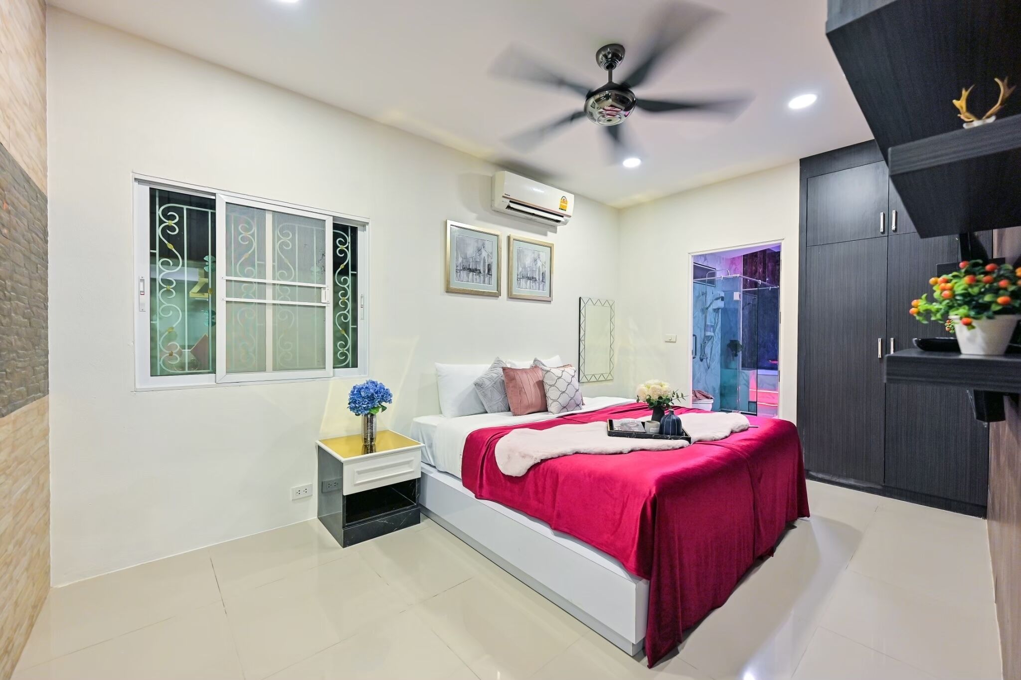 A modern bedroom with a bed, bedside table, and a ceiling fan.