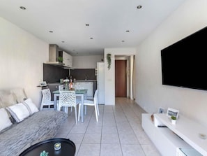 A modern apartment with a living room, dining area, and kitchen.
