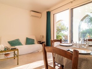 Een kamer met een bed, een tafel met stoelen en een raam met uitzicht op het omliggende landschap.