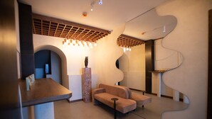 A modern lobby with a curved wall, a seating area, and a reception desk. - FORest 1961 Hotel & Restaurant (Vanadzor)