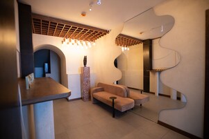 Un vestíbulo moderno con una pared curva, una zona de estar y un mostrador de recepción.