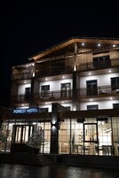 Un hotel de varios pisos con un letrero que dice "FOREST HOTEL".