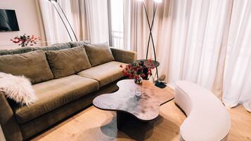 Ein modernes Wohnzimmer mit einem braunen Sofa, einem einzigartigen Couchtisch und einem runden Hocker.