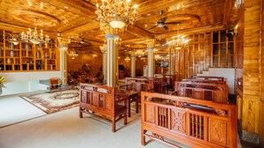 A spacious lobby with wooden paneling, ornate chandeliers, and traditional furniture. - Nam Hong Hotel (Binh Nguyen)