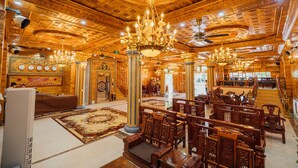 A grand lobby with ornate chandeliers, wooden columns, and traditional furniture. - Nam Hong Hotel (Binh Nguyen)