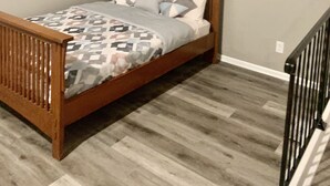 Un dormitorio con cama de madera, colcha estampada y cabecera de madera.
