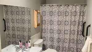 Un baño con dos lavamanos, un inodoro y una cortina de ducha.