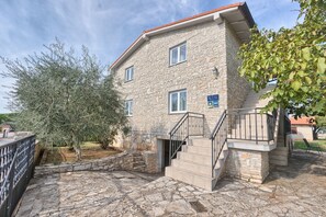 Traditional architecture meets serene surroundings, with a balcony offering a view of the surrounding landscape.