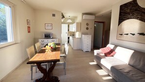 Un espace de vie compact comprenant un coin repas, une kitchenette et un canapé.