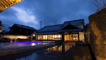 A traditional Japanese building with a stone pathway leading to a wooden structure.