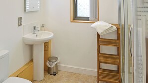 A bathroom with a toilet, sink, and shower area.