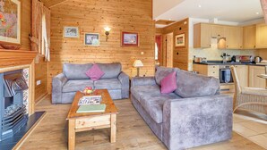 Ein gemütliches Wohnzimmer mit zwei Sofas, einem Couchtisch und einem Kamin.