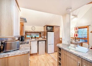 A modern kitchen with granite countertops, stainless steel appliances, and wooden cabinetry.