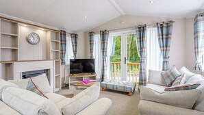 A living room with a television, sofa, and a fireplace. - 2 bedroom accommodation in Calthwaite, Nr Penrith (Calthwaite, Nr Penrith)
