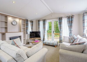 A living room with a television, sofa, and a fireplace. - 2 bedroom accommodation in Calthwaite, Nr Penrith (Calthwaite, Nr Penrith)