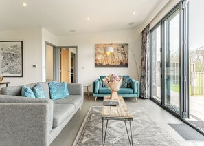 A modern living room with two sofas, a coffee table, and a large window. - 2 bedroom accommodation in Lewes (Lewes)