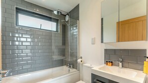 A bathroom with a bathtub, toilet, and sink. - 2 bedroom accommodation in Lewes (Lewes)