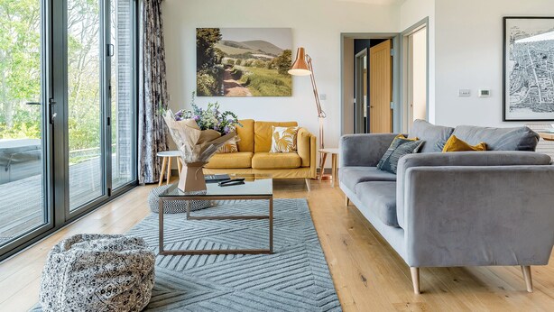 A modern living room with a sofa, a coffee table, and a lamp.