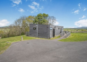 A modern, rectangular building with a flat roof, a small window, and a door. - 1 bedroom accommodation in Lewes (Lewes)