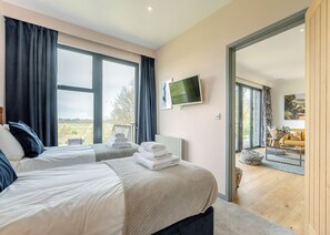 A hotel room with two beds, a TV, and a view of the outdoors. - 2 bedroom accommodation in Lewes (Lewes)