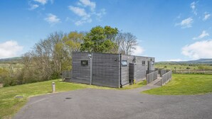 A modern, rectangular building with a flat roof, a small window, and a door.