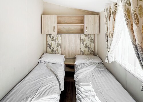 Modern and contemporary 12ft-wide caravan with one double and one twin.