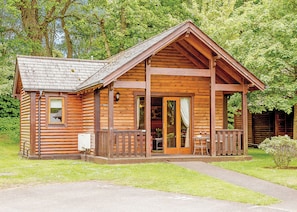 A log cabin with a porch, a dining area, and a visible number '31'. - Cobbett Traditional Premier (Tilford, Farnham)