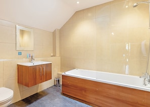 A modern bathroom with a wooden vanity, a large bathtub, and a shower. - Cobbett Traditional Premier (Tilford, Farnham)