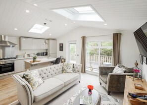 Un espacio habitable moderno con cocina, comedor y balcón.