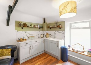 A kitchen with white cabinets, a marble backsplash, and a window with a view. - Kielder Forest Lodge (Kielder)