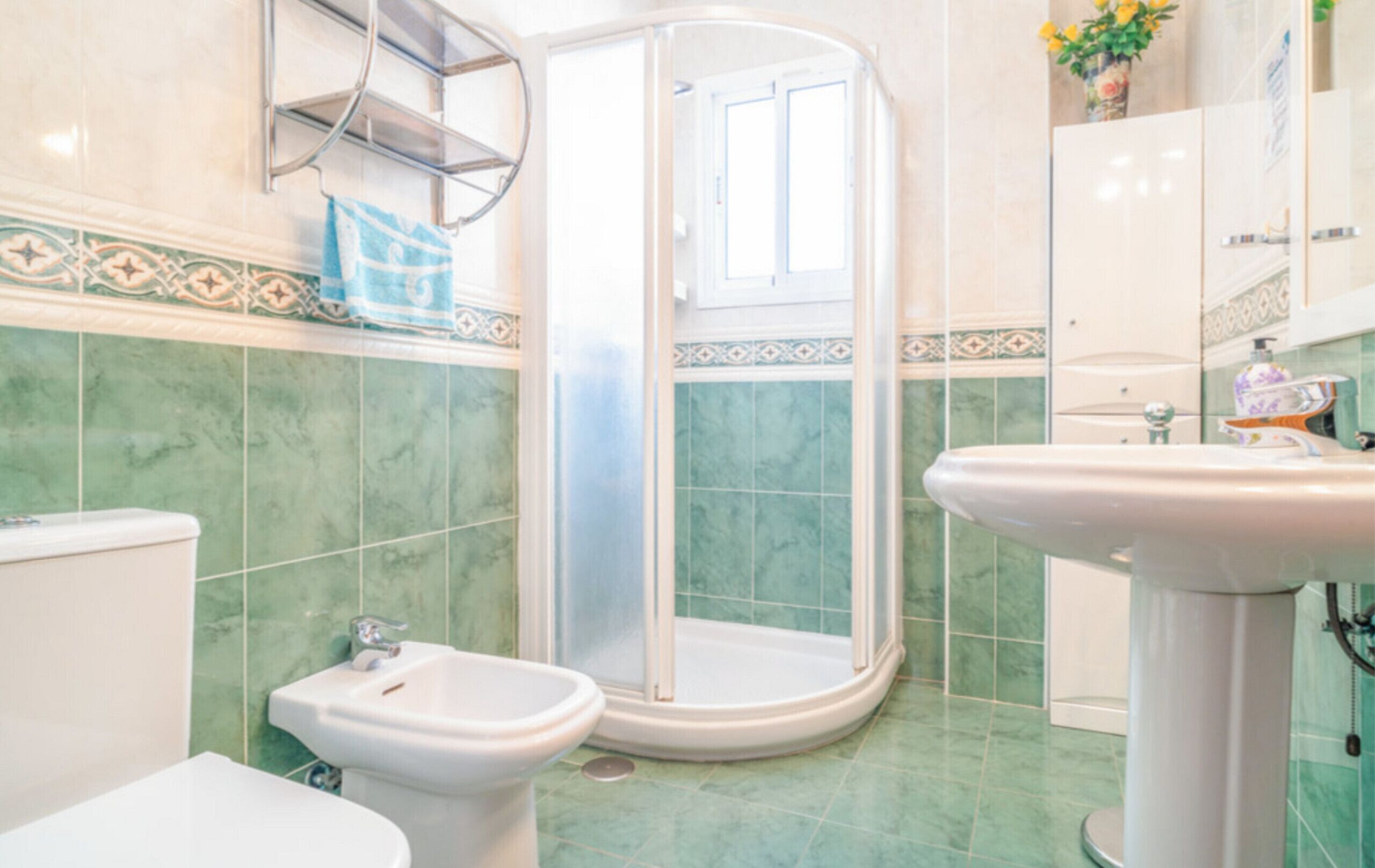 Une salle de bain équipée d’une douche, de toilettes, d’un bidet et d’un lavabo.