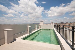 Ein Dachpool mit freiem Blick auf die Skyline der Stadt im Hintergrund.