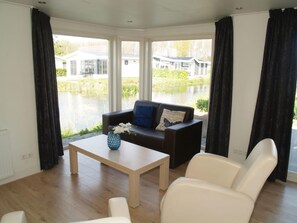 Enjoy a serene view of the water from this stylish living room, featuring a sofa and coffee table.