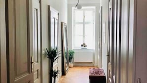 A hallway with wooden flooring, a bench, and a potted plant. - Riverside Apartment Ljubljana with free parking (Ljubljana)
