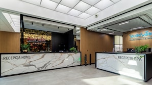 A hotel reception area with marble reception desks labeled "RECEPTION HOTEL" and "RECEPTION SPA." - Hotel Sante (Warsaw)