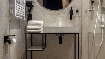 A modern bathroom with a toilet, sink, and shower.