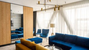 A modern living room with a sectional sofa, armchairs, and a coffee table. - Hotel Sante (Warsaw)